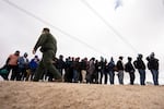 FILE - Men seeking asylum, including Peruvians, line up as they wait to be processed after crossing the border with Mexico nearby, on April 25, 2024, in Boulevard, Calif.