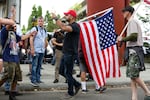 Patriot Prayer leader Joey Gibson directs people back to the west side of the Willamette River during demonstrations in Portland, Ore., Saturday, Aug. 17, 2019.