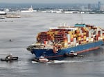 In this aerial view, tug boats maneuver the damaged container ship Dali through the Port of Baltimore and into the Seagirt Marine Terminal on May 20 in Baltimore, M.D. 