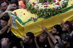 Hezbollah fighters carry one of the coffins of four fallen comrades who were killed Tuesday after their handheld pagers exploded, in the southern suburb of Beirut, Lebanon, Wednesday, Sept. 18, 2024.