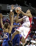 Portland Fire guard Stacey Thomas (11) goes to the basket against Washington Mystics' Annie Burgess, left, and Vicky Bullet during the first half Friday, June 28, 2002, in Portland, Ore.