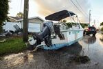 A boat rests on a street after being relocated during flooding caused by Hurricane Helene Friday, Sept. 27, 2024, in Hudson, Fla.