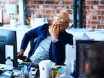 Tired man sitting at desk in modern office