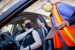 Annalisa Birt of Portland, left, prepares for her vaccination from Marlene Ikeda at a drive-thru mass COVID-19 vaccination clinic at Portland International Airport, April 9, 2021.