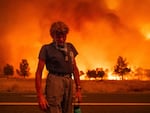 Grant Douglas pauses while evacuating as the Park Fire jumps Highway 36 near Paynes Creek in Tehama County, Calif., on Friday.