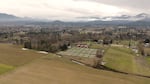 Red barns set in wide Oregon hilly landscape.
