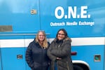 Two women stand in front of an ambulance converted into a mobile needle-exchange unit.