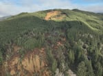 This aerial photo supplied by the Lincoln County Sheriff on Dec. 12, 2025 shows a landslide that came down on Oregon Highway 229 north of Siletz. A home is visible at the bottom of the photo.