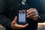 Gabriel Martinez Garcia, 30, poses with an email advertisement from attorney Lozano displayed on his phone in Tenino, Wash., on Sunday, June 14, 2026.