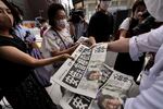 An employee of the Yomiuri Shimbun distributes extra editions of the newspaper in Tokyo with reporting on the shooting of Japan's former Prime Minister Shinzo Abe on Friday.