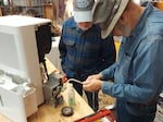 Dick Park, left, and John Goertzen are volunteers at the Repair Cafe, a monthly event held at The Refindery in Wheeler, OR, where community members can bring in appliances and other objects like a dehumidifier to fix. Park and Goertzen are shown in this photo attempting to repair a dehumidifier at a Repair Cafe event held on October 14, 2023.