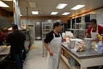 (From left to right) Katherinne Granados and Jessica DeCort package corn tortillas while Ulises Lovata and Joel Hernandez make bread to sell at the El Torito supermarket location in Madras.