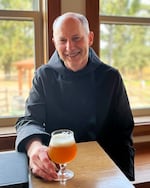 Father Martin tastes a new batch of beer and ponders the flavor profile.