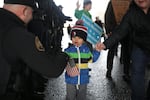 A little boy marching along with his mother, fist bumps a police officer during the Women's March on Portland, Saturday, Jan. 21, 2017.