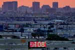 A sign displays an unofficial temperature as jets taxi at Sky Harbor International Airport at dusk, July 12, 2023, in Phoenix.