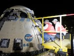 This handout image supplied by NASA shows  Boeing and NASA teams work around NASA's Boeing Crew Flight Test Starliner spacecraft after it landed uncrewed at White Sands Space Harbor, on Friday at White Sands, N.M.