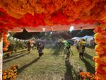 Dancers of Danza Azteca Tezcatlipoca circle the grounds of the front fields of the Historic Oakwood Cemetery in Raleigh, North Carolina during a ceremonial dance in front of Day of the Dead ofrendas to inaugurate the launch of Día de Oakwood on Oct. 26, 2024.