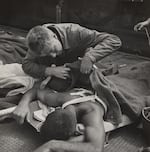 Victor Jorgensen (American, 1914-1994), Untitled (Corpsman checks wounds) from 1945.