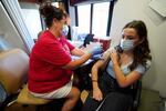 Hy Vee pharmacist Tiffany Aljets, left, gives a COVID-19 vaccination shot to eighteen-year-old exchange student Jonila Shehu, of Kosovo, Monday, Aug. 16, 2021, in Des Moines, Iowa. At the Iowa State Fair in Des Moines, where a million people are expected for the 11-day event, public health officials hope a vaccination station set up by pharmacists working for the Hy Vee food store chain will entice some of the vaccine-hesitant to get their shots. Visitors are packing in to state fairs in multiple Midwest states as COVID activity is increasing, raising concerns about the potential for rapidly accelerating spread of the delta variant of the COVID-19 virus.