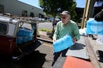 Mike Horner loads his pick-up with water from Multnomah County that he'll hand out to homeless people during the heat this weekend. Northeast Portland, June 11, 2026