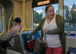 Michelle West gathers her bags in preparation to exit the MAX Blue Line in East Portland, Ore., Sept. 22, 2025. 