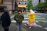 J. Schuberth, who is running for Oregon governor as “Pencil” and dresses the part, speaks with voters and curious passersby as they walk around downtown Portland, Ore., to campaign on April 23, 2026.