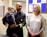 Surgeon General Jerome Adams holds 15-month-old Everett Banse-Fay. His mother, Cerise Wilson, was initially hesitant to fully vaccinate him after talking to friends and going on-line to find information.