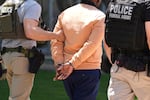 Federal agents take someone into custody after an immigration court hearing outside immigration court on May 21, 2025, in Phoenix.