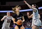 Portland forward Lucy Cochrane, center, looks to shoot against Gonzaga guard Brynna Maxwell (22) and Gonzaga forward Maud Huijbens during the second half of an NCAA college basketball game in the finals of the West Coast Conference women's tournament Tuesday, March 7, 2023, in Las Vegas.