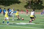 Junior Reyes, center, takes a shot on goal during tryouts for the Tri-Cities Badgers FC semi-pro soccer team at Fran Rish Stadium in Richland, Wash., in March 2024.