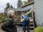 Reggie Windham (right) points out some of the danger spots outside of Peggy Strain's home in Ashland.