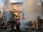 Israeli security and rescue forces work at the site hit by a rocket fired from Lebanon, in Kiryat Bialik, northern Israel, on Sunday, Sept. 22, 2024.