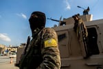 U.S.-backed Syrian Democratic Forces (SDF) fighters stand guard at Al Naeem Square, in Raqqa, Syria, Monday, Feb. 7, 2022.