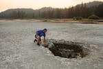 Brent McGregor peers into a second large hole in the bed of Lost Lake, revealed late in the season after waters receded.