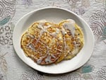 Pancakes with icing on a white plate.