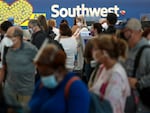 Travelers wait to check in at the Southwest Airlines ticketing counter at Baltimore Washington International Thurgood Marshall Airport on October 11, 2021 in Baltimore, Maryland.