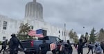 A truck speeds through a group of anti-fascist protesters as they gathered in the streets near the Oregon state Capitol building on Sunday, March 28, 2021.