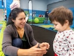 Bend nurse Ana Carteño scoops up her 13-month-old son Theo during a toddler holiday party in Bend, Dec. 18, 2024.