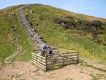 A fence protects the site of the Sycamore Gap tree's stump on the Hadrian’s Wall Path National Trail, where new shoots recently appeared.