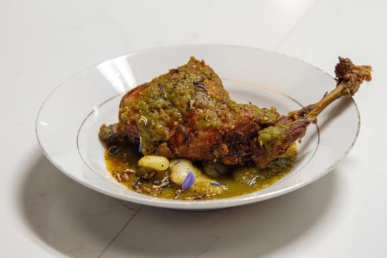 Wild Rabbit Leg is a first foods dish with braised wild rabbit topped with a verde sauce, house made tajín, on a bed of lima beans and puffed wild rice.