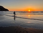 A member of the Pacific Northwest Living Historians fetches a bucket of seawater from the ocean.