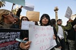 People lift placards during a rally called for by Syrian activists "to mourn for the civilian and security personnel casualties," at al-Marjeh square in Damascus on March 9.