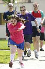 Jessica Rambaum, 17, of Roseburg, Ore. leads the way as Jerry Vanderhoff of Winston, Ore., carries the Special Olympics torch on Tuesday, July 10, 2012.
