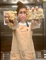 Baker Serena Zendejas holds a raspberry scone and a "magic bar" -- two of the four varieties of treats in the "Baked PDX" lineup.