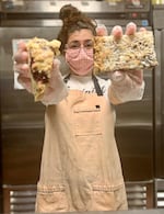 Baker Serena Zendejas holds a raspberry scone and a "magic bar" -- two of the four varieties of treats in the "Baked PDX" lineup. 