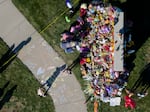 People visit a memorial in front of Silver Rail Elementary School in Bend, Ore., Friday, Oct. 16, 2026, where community members have created a makeshift memorial. 