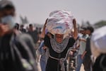 A Palestinian woman carries a bag of food delivered by the Gaza Humanitarian Foundation, a U.S.-backed organization, in Rafah, southern Gaza Strip, June 11.
