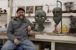 Sculptor Scott Foster sits next to a bust of a fawn made out of clay on Nov. 11, 2021. Foster’s Gaston, Oregon, studio doubles as a museum of sorts for his past projects which range from the bright and elaborate, to wondrous and weird.