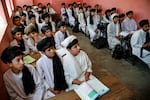 Afghan school boys wearing Taliban-imposed new uniforms of turbans and long tunics attend a class at a school in Herat on May 4, 2025.