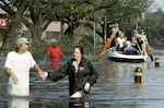 People on Canal street make their way to higher ground as water fills the streets August 30, 2005 in New Orleans, Louisiana.